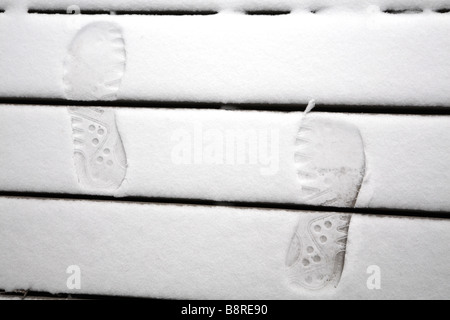Footprints in snow on wooden steps. Stock Photo