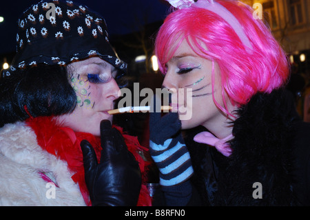 portrait of colourful friends lighting a cigarette at Carnival Roermond Netherlands Stock Photo