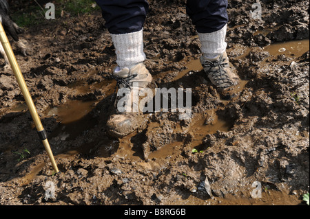 Walking boots stuck in mud on walker Stock Photo