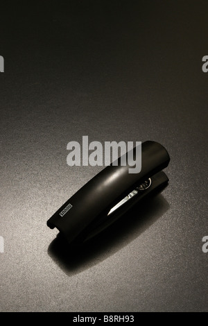 a tacker on a black background in dramatic lighting Stock Photo
