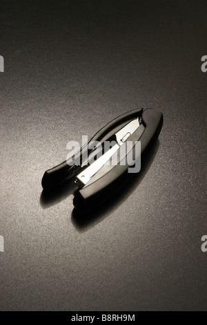 a tacker on a black background in dramatic lighting Stock Photo
