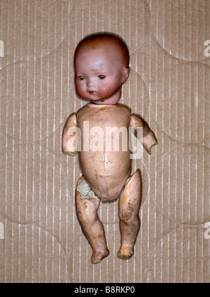 Studio shot of  damaged toy doll in a cardboard box. Stock Photo