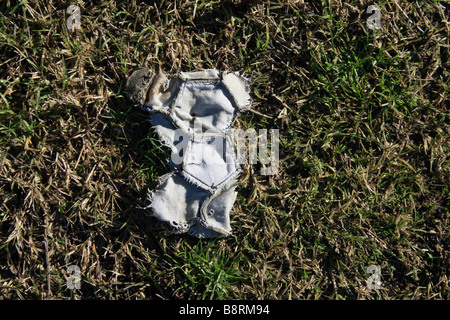 part of one old damaged leather football in field Stock Photo