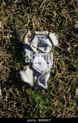 part of one old damaged leather football in field Stock Photo