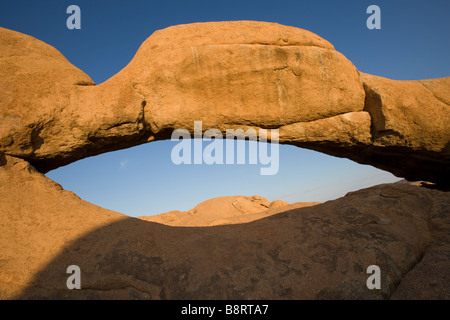 Africa Namibia Usakos Setting sun lights granite arch near Spitzkoppe mountain in Namib Desert Stock Photo