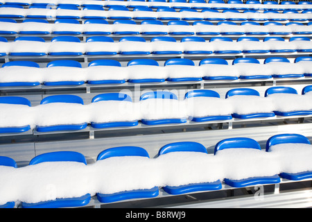 Snow covered blue plastic seats at Finnish soccer stadium stand , Finland Stock Photo