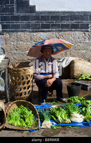 Woman selling vegetables on a street in Lijiang, Yunnan Province, China. Stock Photo