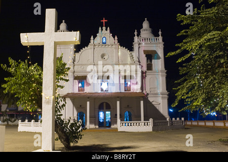 Varca square infront of catholic church at night in christmass garland lights decoration with large white stone cross. Stock Photo