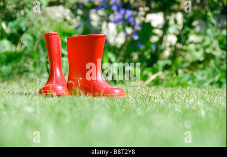 Low-angle shot of child's red Wellington boots on a lawn