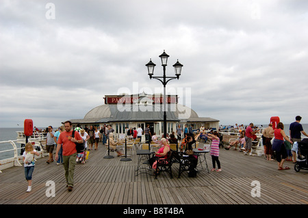 People walking on Cromer pier on an overcast day Stock Photo