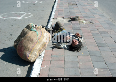 A homeless man sprawled out on the street in the town of Duitama, Colombia Stock Photo