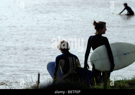 Surfers waiting for the Severn Bore at Minsterworth Gloucestershire Stock Photo