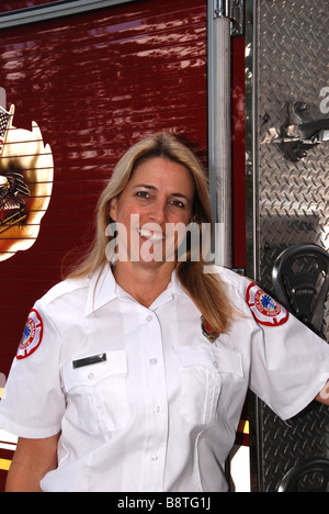 Female firefighter paramedic in dress uniform posing in front of fire ...