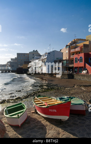 Typical Canary fishing boats on the quay and coastal restaurants at El Medano south Tenerife Canary Islands Spain Stock Photo