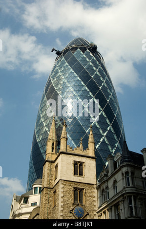 The Gherkin building in London with an old church in the foreground Stock Photo