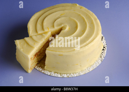 Iced lemon sponge cake with slice cut out Stock Photo