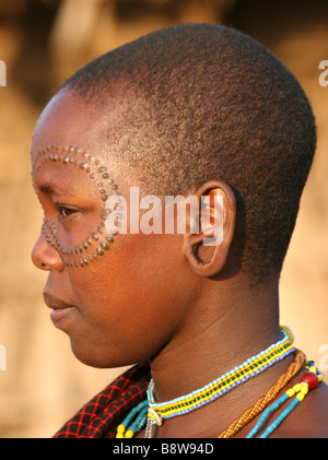 Africa Tanzania members of the Datoga tribe Woman in traditional dress beads and earrings Beauty scarring around her eyes Stock Photo