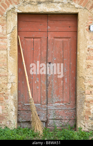 A dilapidated broom leans in a rural doorway in Petrognano, Tuscany, Italy. Stock Photo