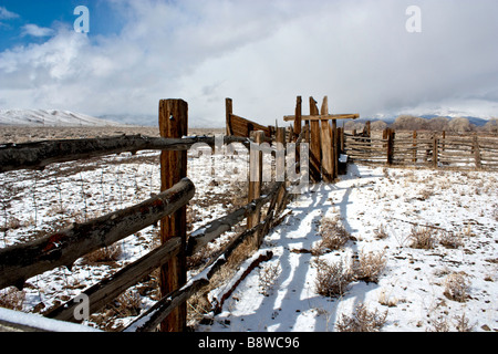 Fresh snow and a weathered wood fence of a corral while a snowstorm approaches Stock Photo
