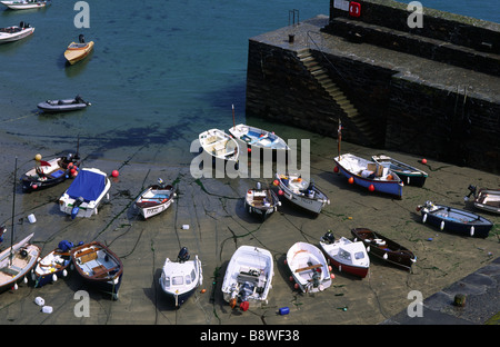 Boats stranded on the beach at low tide in the pretty fishing village of Gorran Haven in Cornwall England Stock Photo