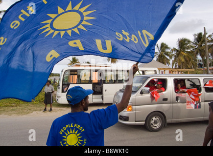 A United Progressive Party UPP supporter waves his flag at Antigua Labour Party supporters on their way to a party political ral Stock Photo