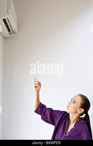 woman turn on air conditioning Stock Photo
