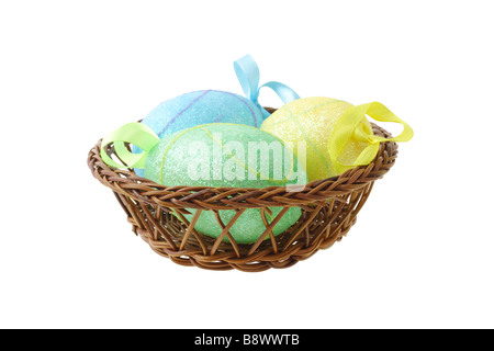 Decorative Easter eggs in basket on white background Stock Photo