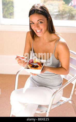 woman eating enjoying fruit salad Stock Photo
