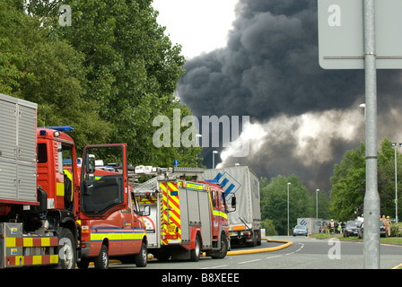 Chemical factory fire showing fire engines and large plume of black smoke Stock Photo