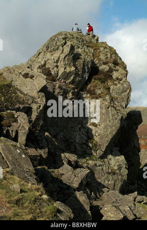Two walkers on top of Helm Crag, Lake District, Cumbria, England, UK. Stock Photo