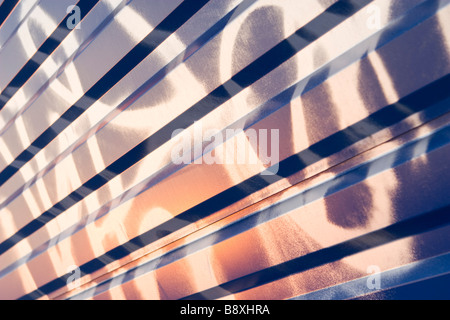 Graffiti painting on waved blue metal sheet pattern on sunset. Stock Photo