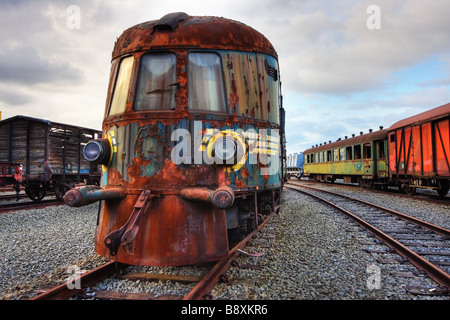Abandoned railroad engine and carriages standing on rusty rails Stock Photo