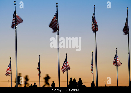 Kids running. American flags at the Washington Monument with visitors at sunset. Washington DC USA. Stock Photo