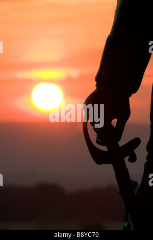 Sunset in Gettysburg National Park with a statue of Major General Gouverneur K. Warren in the foreground holding a sword. Stock Photo