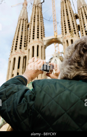 A woman taking photographs of the Sagrada Famlia in Barcelona Spain. Stock Photo