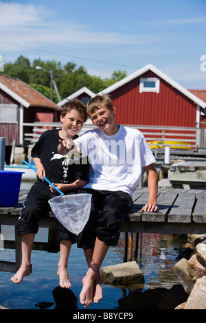 Two boys fishing crabs Smogen Bohuslan Sweden. Stock Photo