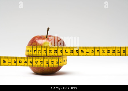 An measuring-tape around an apple close-up. Stock Photo