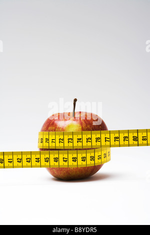 An measuring-tape around an apple close-up. Stock Photo