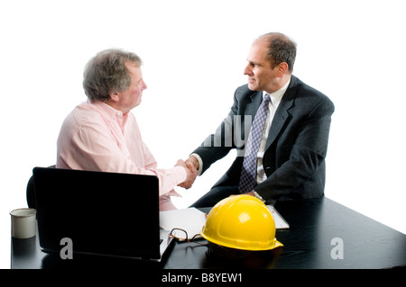 Two business senior executive partners shaking hands in office. Client and contractor construction architect making deal. Stock Photo