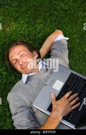 A man with a laptop in a park Sweden. Stock Photo