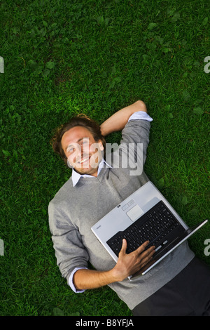 A man with a laptop in a park Sweden. Stock Photo