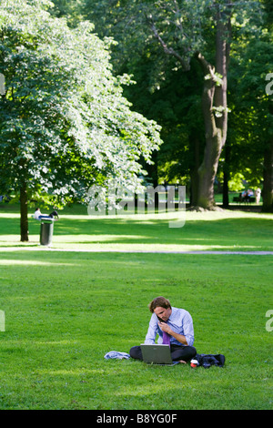 A man with a laptop in a park Sweden. Stock Photo