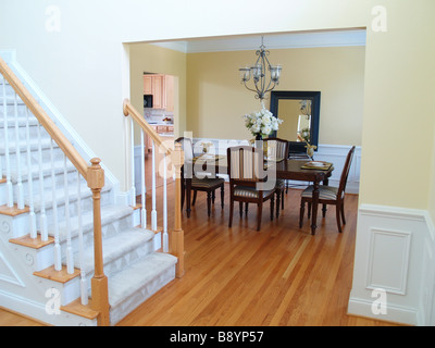 A well staged dining room viewed from the foyer with the staircase in the foreground