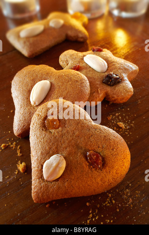 Fresh baked spicy christmas biscuits in s festive setting on a wooden table Stock Photo