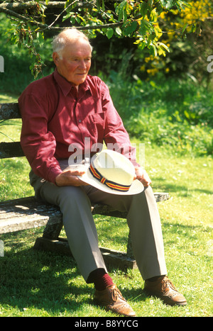 elderly man sitting outside in the sunshine looking lonely and isolated Stock Photo