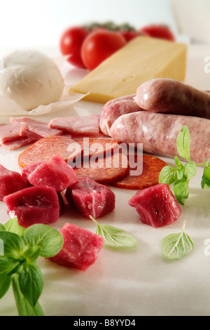 Beef Chunks Salami raw sausages ham plus buffalo mozerella Cheddar on marble Stock Photo
