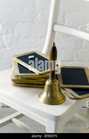 The school handbell and slates on a chair at The Workhouse Southwell Nottinghamshire a C19th institution for paupers Stock Photo