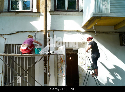 Two women plaster a wall in Odessa Ukraine Stock Photo