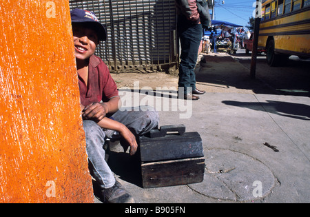 A young boy in Guatemala working as a shoe shine boy Stock Photo