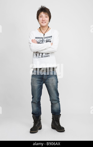 Portrait of a young man standing with arms crossed Stock Photo